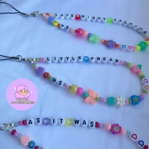 May include: Three colorful beaded phone charms with the phrases "Late Night Talking", "Little Freak", and "As It Was". Each charm features a variety of colorful beads, including hearts, smiley faces, flowers, butterflies, and strawberries.