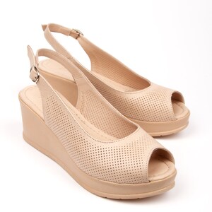May include: Beige peep-toe wedge sandals with a slingback strap and a perforated design.