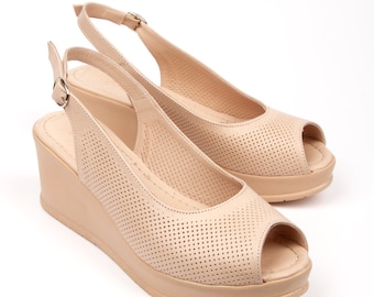 Beigefarbene Peeptoe-Keilsandalen aus Leder mit perforiertem Obermaterial, gepolsterter Innensohle, Slingback-Riemen und stabilem Absatz für lässige oder halbformelle Kleidung