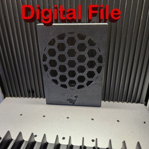 May include: A black 3D printed object with a honeycomb pattern and a small logo. The object is on a gray surface with a black background.