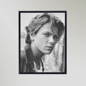 May include: Black and white portrait photograph of a young man with tousled hair. He is wearing a dark jacket and looking directly at the camera.