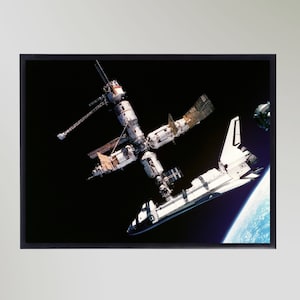 以下が含まれることがあります： 地球の周回軌道上にある国際宇宙ステーションにドッキングした白いスペースシャトル。シャトルはカメラの方を向いており、宇宙ステーションはカメラに対して垂直になっている。地球が背景に見えている。