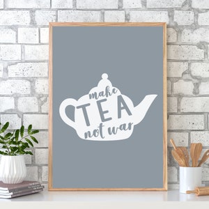 Pode incluir: Uma impressão emoldurada com fundo cinza e uma silhueta branca de um bule de chá com o texto "make tea not war" nela.