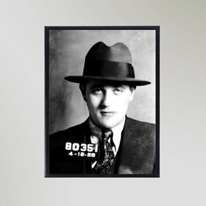 Può includere: Foto segnaletica in bianco e nero di un uomo con un cappello fedora e un abito. Il numero di foto segnaletica 80351 e la data 4-12-28 sono visibili nell'angolo in basso a sinistra.