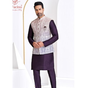 May include: A formal outfit comprising a purple kurta and trousers, paired with a patterned waistcoat. The waistcoat has a cream base with detailed paisley patterns in purple and red. The ensemble is finished with dark brown leather shoes.