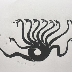 Peut inclure: Gravure sur linoléum en noir et blanc d'une créature mythique à plusieurs têtes et au corps serpentiforme.