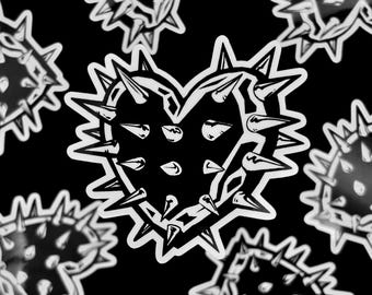May include: A black and white sticker sheet featuring multiple heart-shaped designs. Each heart is outlined in white and covered in sharp, pointed spikes. The stickers have a glossy finish and are set against a solid black background.