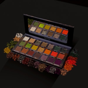 May include: A rectangular eyeshadow palette by Ensley Reign featuring twenty square pans of pressed powder pigments in shades of green, orange, red, brown, and purple, with a mirror inside the lid and loose pigment swatches surrounding the base.