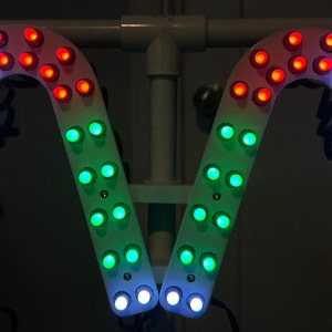 May include: Two white candy cane shaped light displays with red, green, and white LED lights.