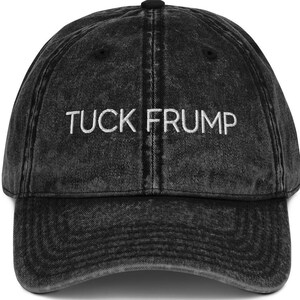 May include: A black vintage-style baseball cap with the text "TUCK FRUMP" embroidered in white on the front.
