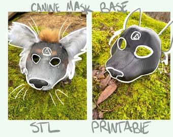 Puede incluir: Una máscara canina gris y negra con pelo en las orejas. La máscara está sobre un lecho de musgo verde. El texto "CANINE MASK BASE" está escrito encima de la máscara. El texto "STL" está escrito debajo de la máscara. En el lado derecho de la imagen hay una máscara negra impresa en 3D. El texto "PRINTABLE" está escrito debajo de la máscara.