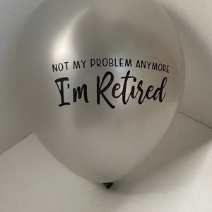 May include: A silver balloon with the text "Not my problem anymore I'm Retired" printed in black.