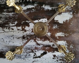 Salvamanteles extensible de latón vintage con diseño de concha ornamentada para platos o macetas.