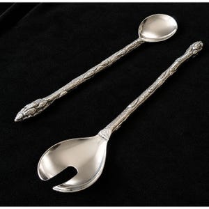 May include: A silver-toned salad serving set consisting of a long-handled spoon and a long-handled slotted spoon. Both utensils feature a textured, branch-like handle design with a polished, smooth bowl and a metallic finish throughout.