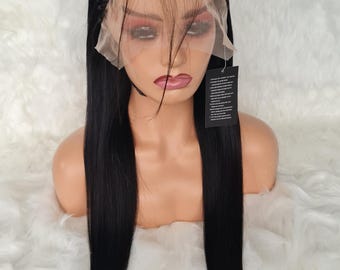 May include: A black human hair wig with long straight hair and a braided lace front. The wig is on a mannequin head and is displayed against a white background.