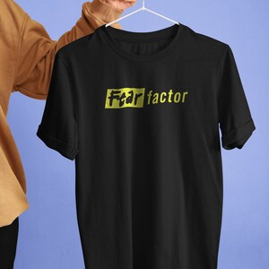 May include: Black t-shirt with a yellow rectangle that says "Fear factor" in black lettering.