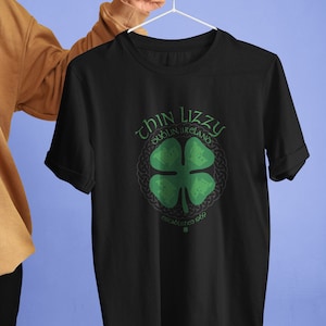 May include: Black t-shirt featuring a green shamrock and the text "Thin Lizzy Dublin, Ireland Established 1969" printed on the front.