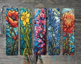 May include: Set of five floral bookmarks with a stained-glass effect. Each bookmark features a different flower: a red poppy, yellow daffodil, pink cherry blossoms, blue hyacinth, and orange chrysanthemum. A silver tassel is attached to the first bookmark.