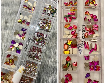 May include: Two clear plastic containers filled with colorful rhinestones and gems. The containers are labeled "CocoStop".