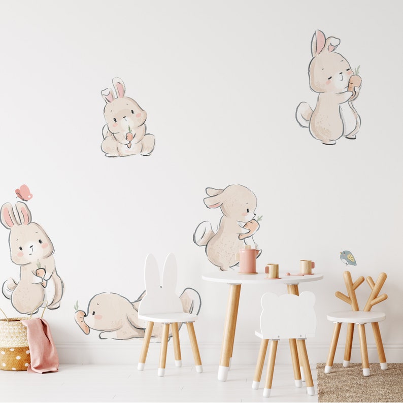 a child's room with a table, chairs, and wall decals