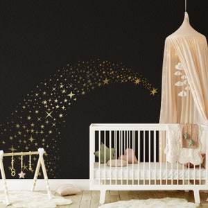 May include: A white cot with a white canopy and a gold star decal on a black wall. The cot has a white mattress and a white blanket with a gold star pattern. There is a white rug on the floor.