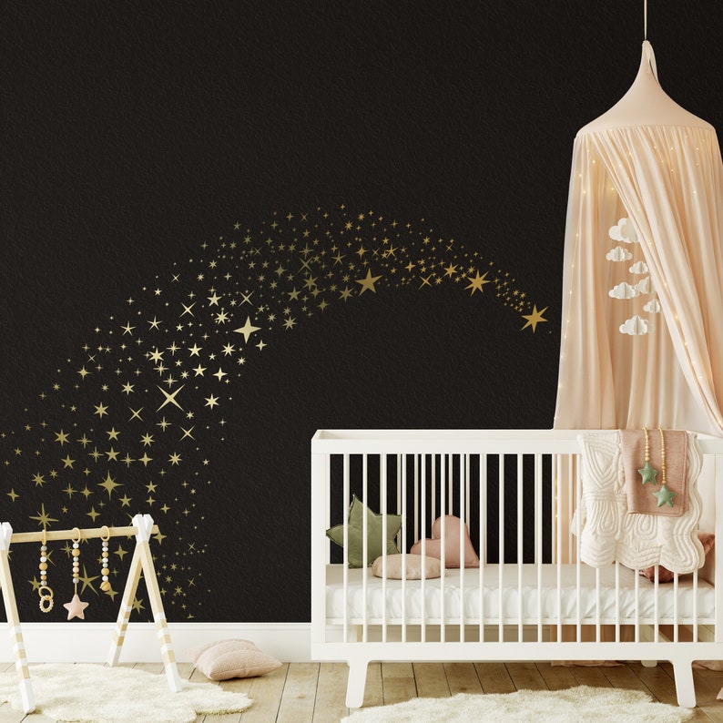 May include: A white cot with a white canopy and a gold star decal on a black wall. The cot has a white mattress and a white blanket with a gold star pattern. There is a white rug on the floor.