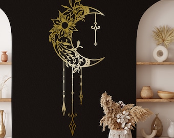 Puede incluir: Una luna creciente dorada con intrincados diseños florales y colgantes. La luna está sobre un fondo negro.
