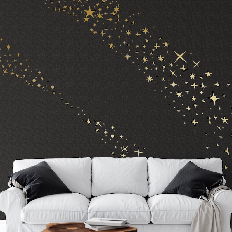 May include: A white sofa with black cushions in front of a black wall with a gold star pattern. The stars are arranged in a curved line.