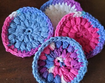 Peut inclure: Quatre tampons démaquillants en crochet de couleur bleue, rose, blanche et violette. Les tampons sont ronds et ont une surface texturée.