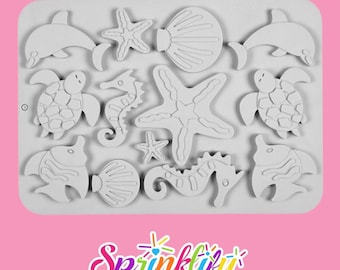 May include: A white silicone mold featuring various sea creatures, including dolphins, starfish, seahorses, turtles, fish, and seashells. The mold is designed for creating decorative elements. The Sprinklify logo is at the bottom.