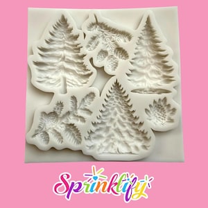 May include: A white silicone mold featuring detailed designs of various pine trees and pine cones. The mold includes several different tree shapes and textures, perfect for crafting or baking. The logo "Sprinklify" is visible at the bottom.