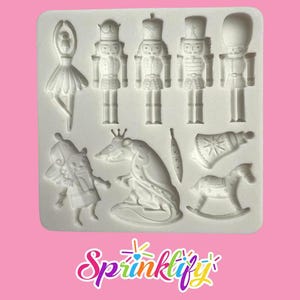May include: A white silicone mould with shapes from The Nutcracker ballet, including a ballerina, nutcracker soldiers, a rat, and a rocking horse. The word "Sprinklify" is written in a colourful, cursive font at the bottom.