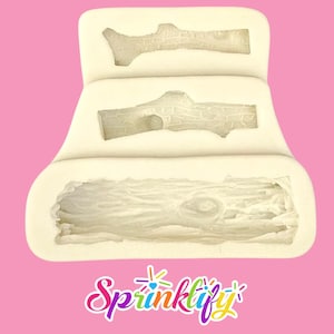 Puede incluir: Un molde de silicona blanco con tres cavidades, cada una con forma de tronco detallado. El molde está diseñado para manualidades, con la palabra "Sprinklify" en escritura colorida en la parte inferior.