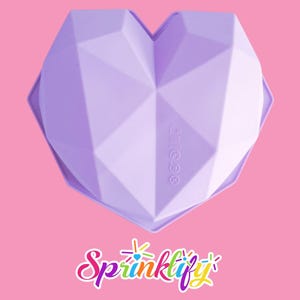 May include: A light purple, heart-shaped silicone mold with a geometric design. The mold has a faceted surface and is designed for baking or crafting. The image is set against a pink background, with the word "Sprinklify" in the bottom corner.