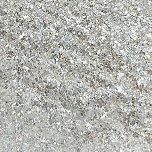 May include: A close-up of a silver glitter background. The glitter is very fine and creates a sparkling effect.