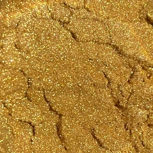 May include: Close-up of a gold glitter texture. The glitter is fine and creates a shimmering effect.