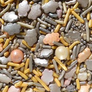 May include: A mix of gold, silver, and peach-colored sprinkles. The sprinkles are in the shape of clouds, stars, and small round balls.