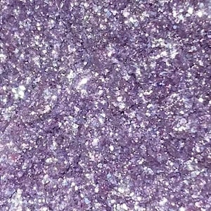 Può includere: Primo piano di glitter viola con un bagliore iridescente. Il glitter è fine e ha una consistenza scintillante.