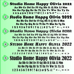 May include: A green and white background with a black font displays a font chart with the alphabet, numbers, and punctuation marks. The font is bold and has a slightly rounded style. The text "Studio Home Happy Olivia 2022" appears at the top of each row.