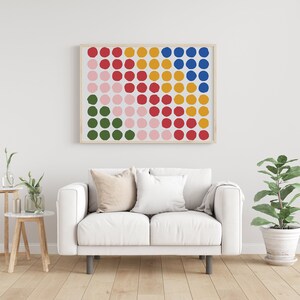 May include: A framed print of a colorful abstract design featuring a grid of circles in shades of red, pink, green, yellow, and blue.