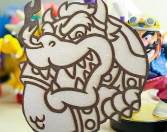 Può includere: Un ritaglio di legno di Bowser, un personaggio della serie di videogiochi Super Mario. Bowser è una grande tartaruga che sputa fuoco con un'espressione minacciosa. Il ritaglio è dipinto in tonalità di marrone e bianco.