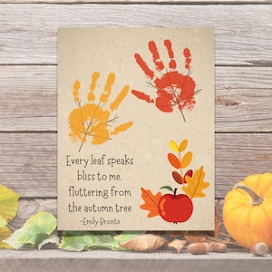 May include: A printable card with a fall theme. The card features handprint leaves in orange and red, a red apple, and a quote by Emily Bronte: "Every leaf speaks bliss to me. fluttering from the autumn tree -Emily Bronte"