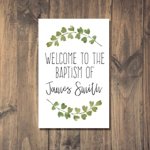 Può includere: Un cartello bianco con foglie verdi ad acquerello intorno ai bordi. Il testo recita "Benvenuti al battesimo di James Smith".