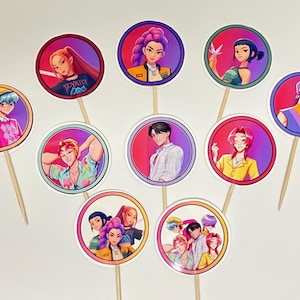 May include: A collection of ten circular cupcake toppers featuring colorful anime-style illustrations of people. Each image is set within a white-bordered circle and attached to a wooden skewer. The characters have various hairstyles and wear different outfits.