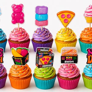 May include: Ten cupcakes arranged in two rows, each topped with colorful frosting, sprinkles, and a decorative topper. Toppers include a jellyfish, gummy bear, stacked blocks, pizza slice, ice cream, Nee Doh logo, fruit, and Squeeza packaging.