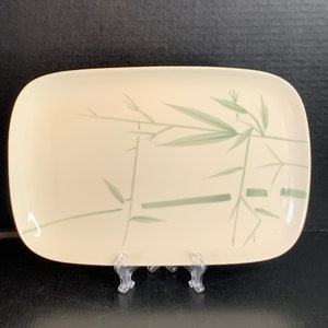 May include: A rectangular serving platter with a white background and a green bamboo design.