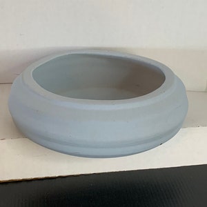 Puede incluir: Un cuenco de cerámica gris claro con forma redondeada y acabado liso y mate.