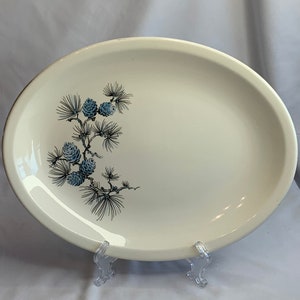 Puede incluir: Plato de servir ovalado blanco con un diseño de rama de pino azul y gris.