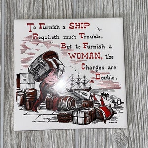 Puede incluir: Un azulejo de cerámica blanco con una ilustración roja y negra de un hombre que lleva barriles a la espalda. El azulejo tiene una cita que dice: "To Furnish a SHIP Requireth much Trouble, But to Furnish a WOMAN, the Charges are Double."