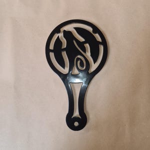 May include: Black metal wall decor featuring a cut-out design of a cat within a circle. The cat is facing right and has a long tail.